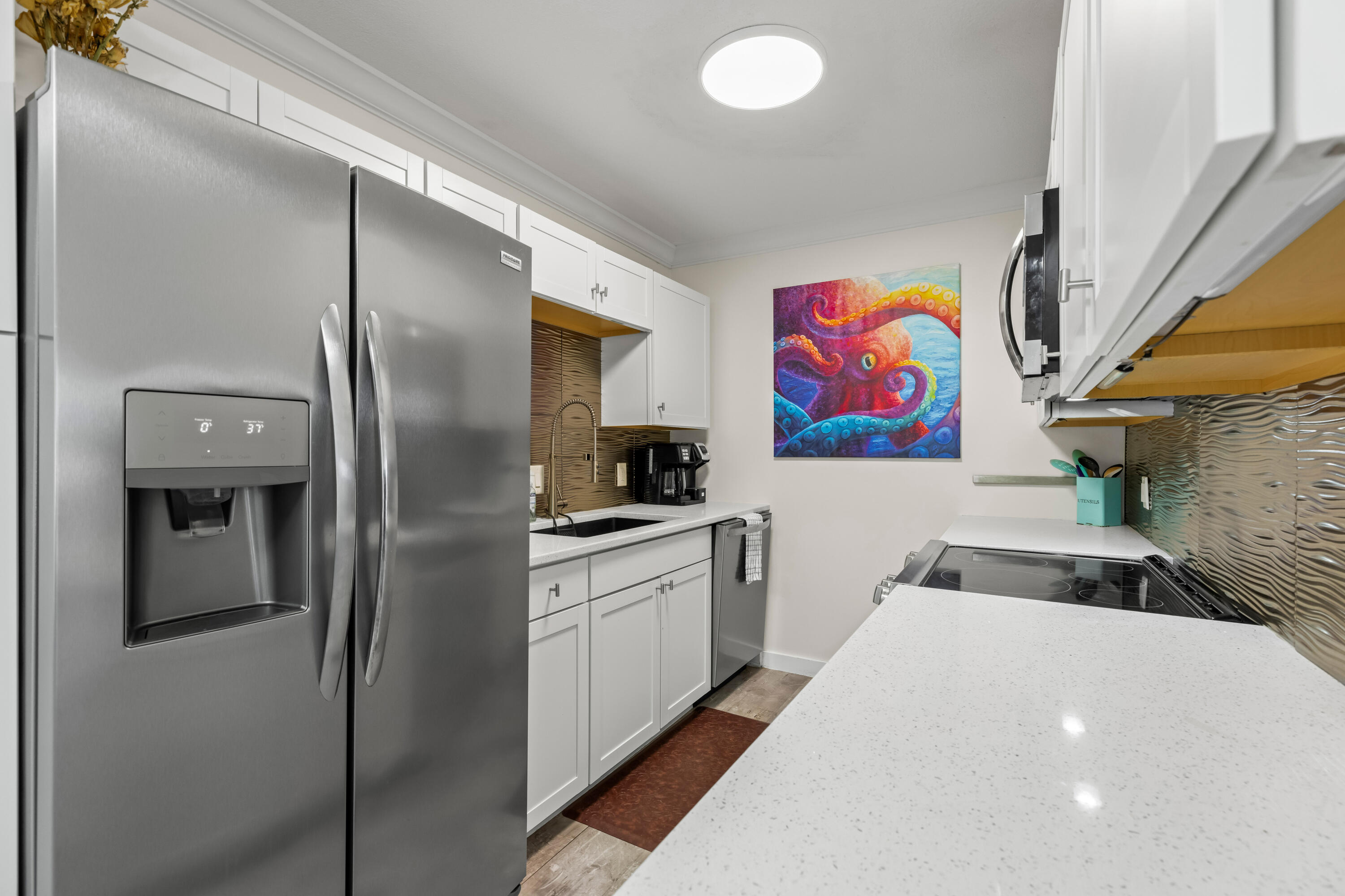 22 Moreno Point Road, Unit 3 Destin, FL 32541 - Photo 21 of 45 a kitchen with stainless steel appliances granite countertop a refrigerator and a sink