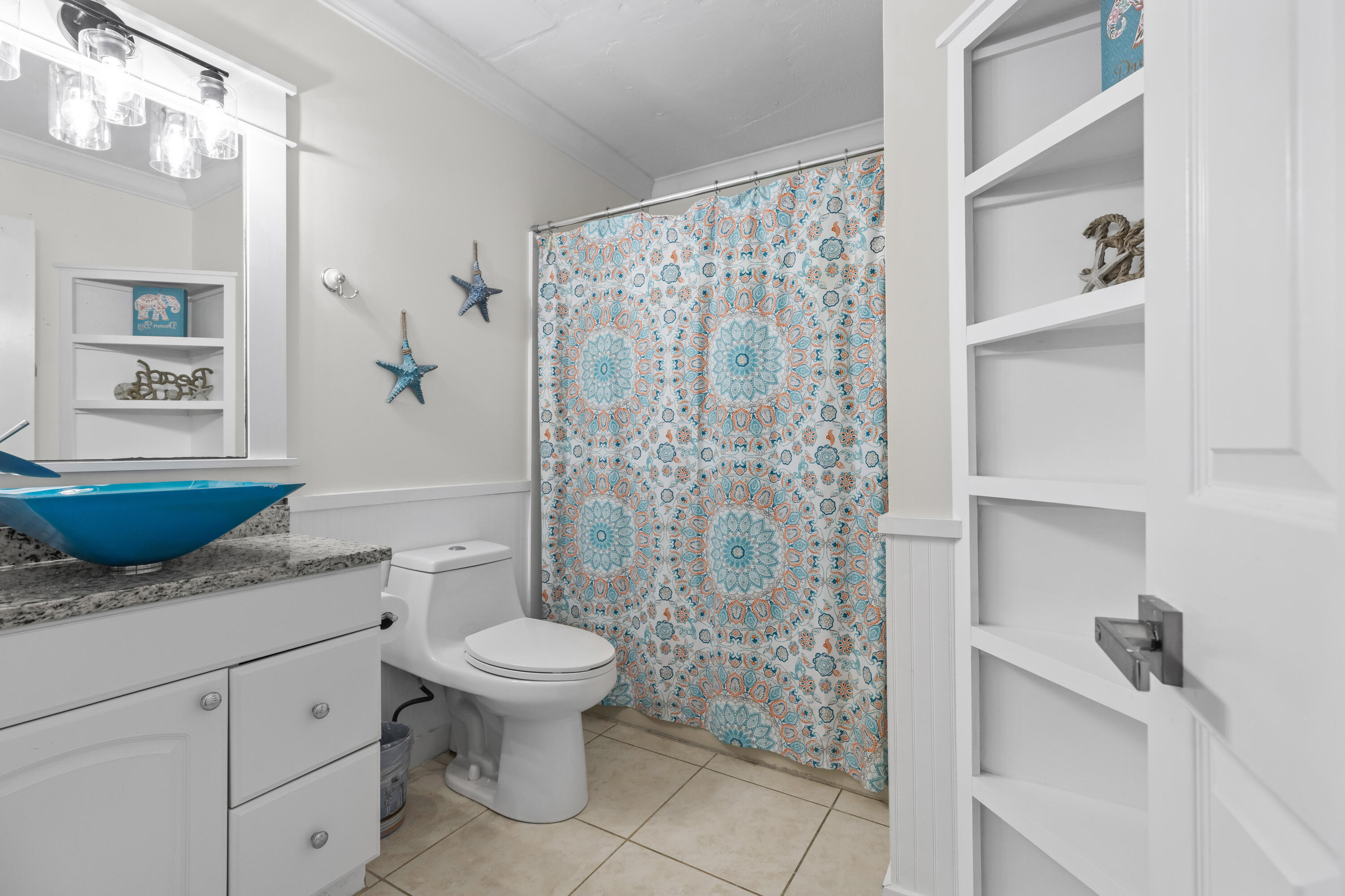 22 Moreno Point Road, Unit 3 Destin, FL 32541 - Photo 38 of 45 a spacious bathroom with a granite countertop sink a mirror a toilet and a shower