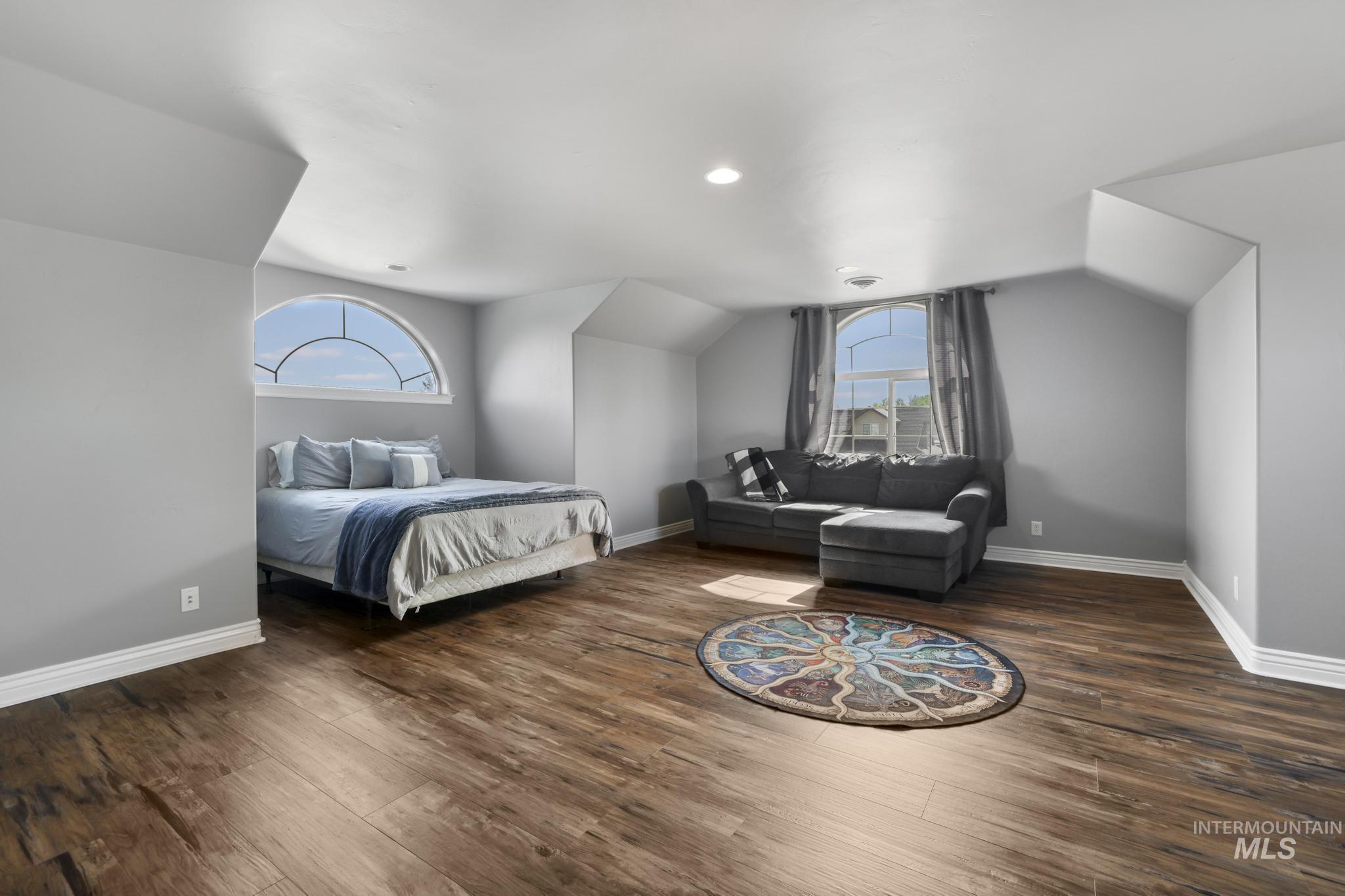 467 Wildrose Loop Twin Falls, ID 83301 - Photo 31 of 46 Spacious room featuring wood-finish flooring, two arched transom windows, recessed lighting, and crisp white baseboards