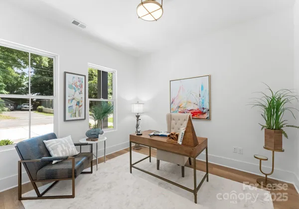 a living room with furniture a window and a potted plant