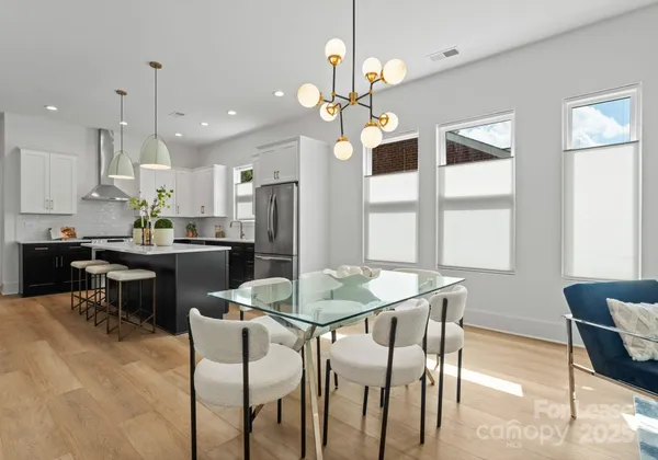 a kitchen with a dining table chairs and refrigerator