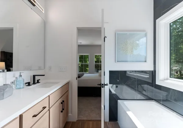 a bathroom with a sink a large mirror and a bathtub