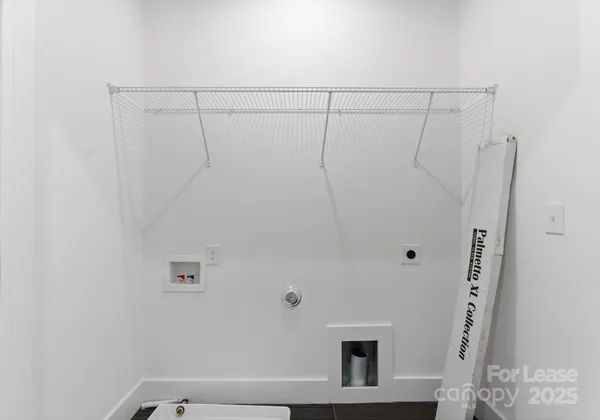 a view of an empty room with a window and kitchen view