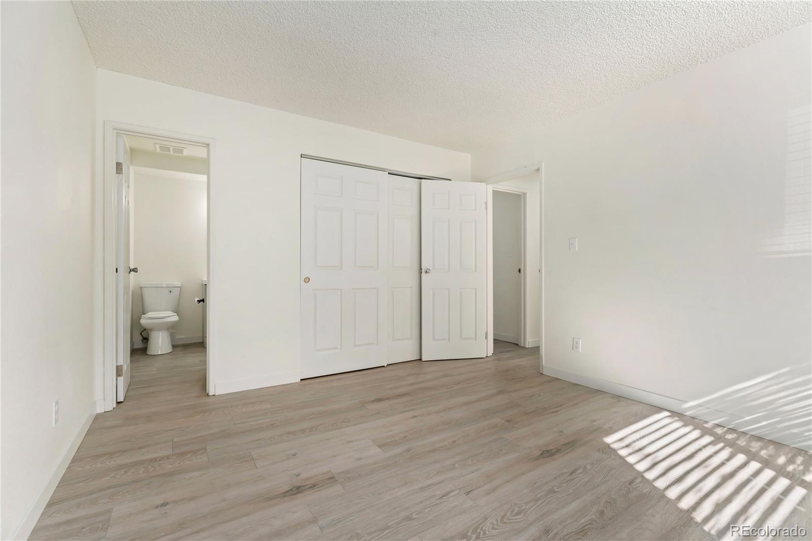 209 East Highline Circle, Unit 108 Centennial, CO 80122 - Photo 11 of 22 a view of a room with wooden floor and a bathroom view