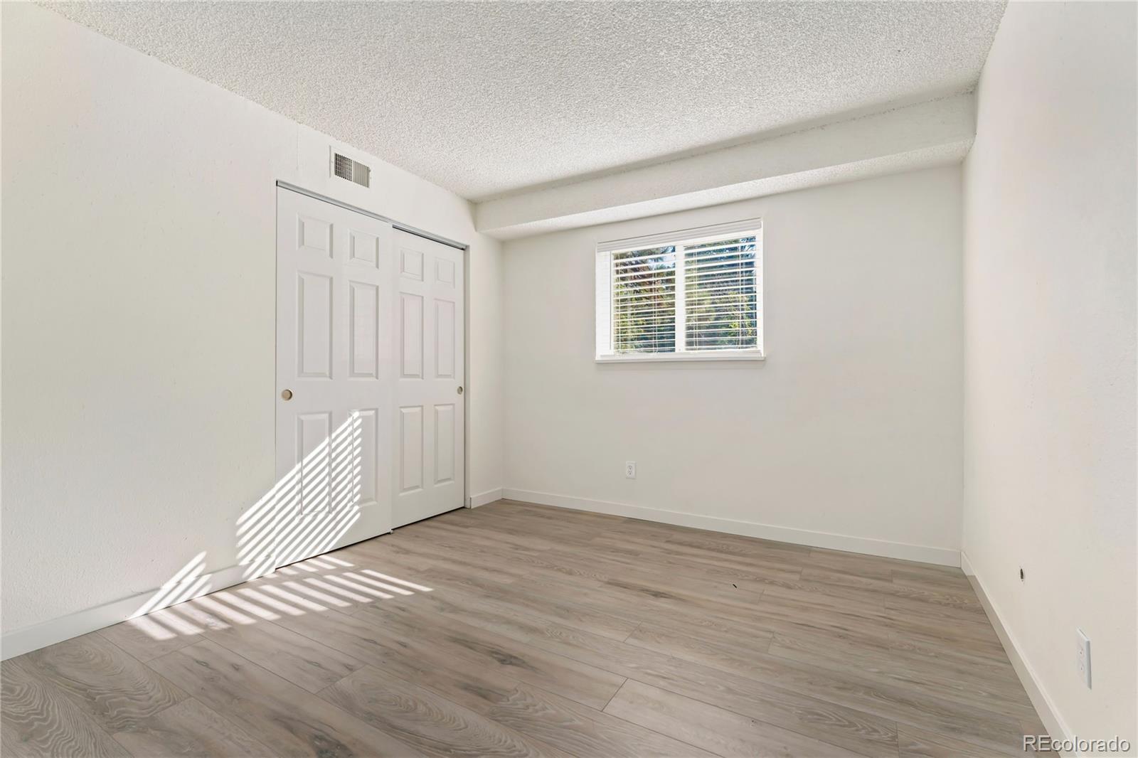 209 East Highline Circle, Unit 108 Centennial, CO 80122 - Photo 13 of 22 an empty room with wooden floor and windows