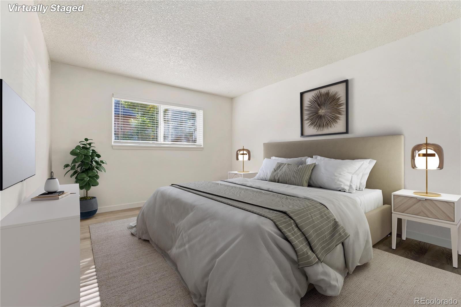 209 East Highline Circle, Unit 108 Centennial, CO 80122 - Photo 4 of 22 a spacious bedroom with a bed and a potted plant