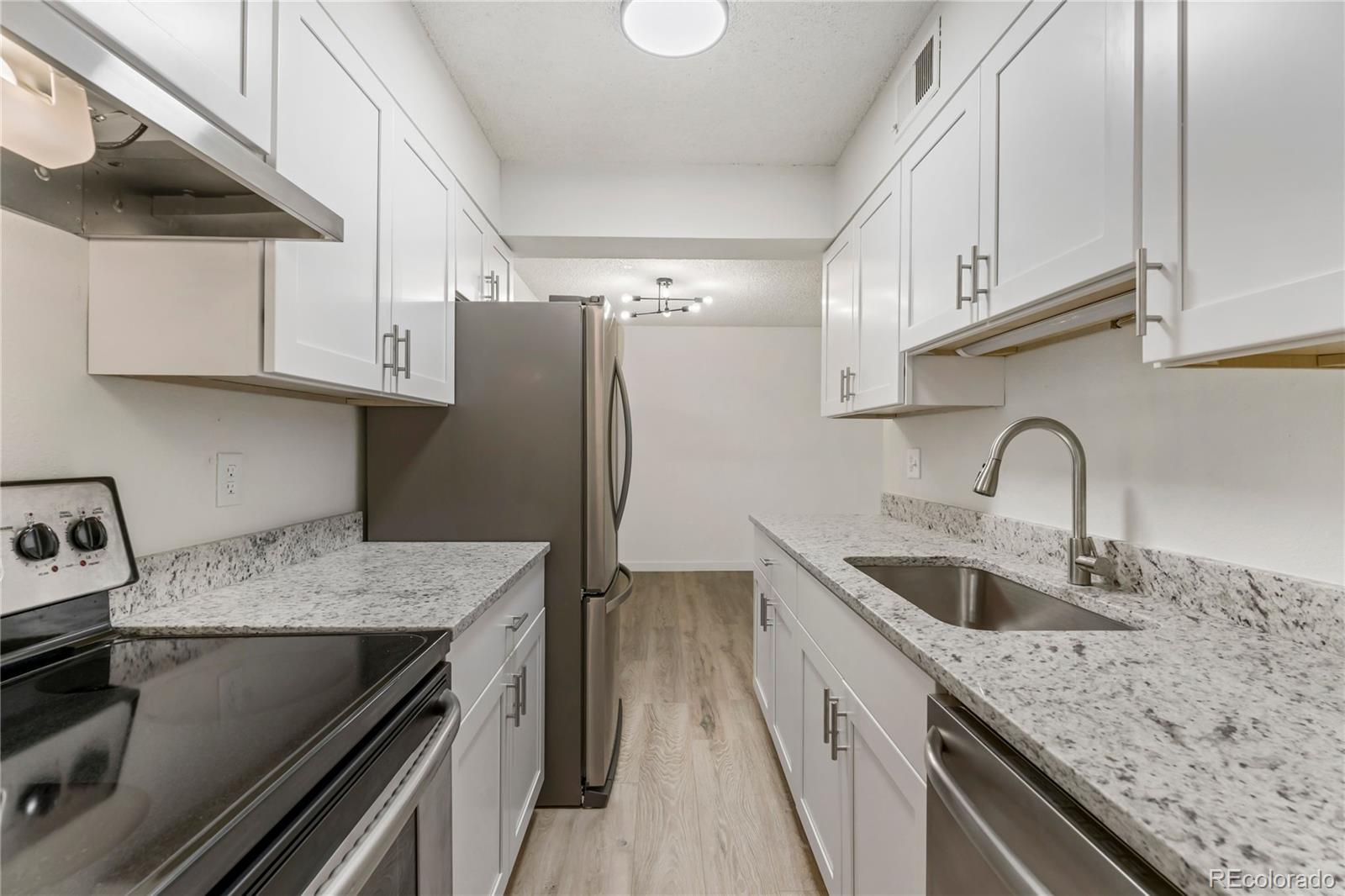 209 East Highline Circle, Unit 108 Centennial, CO 80122 - Photo 5 of 22 a kitchen with stainless steel appliances granite countertop a sink stove and refrigerator