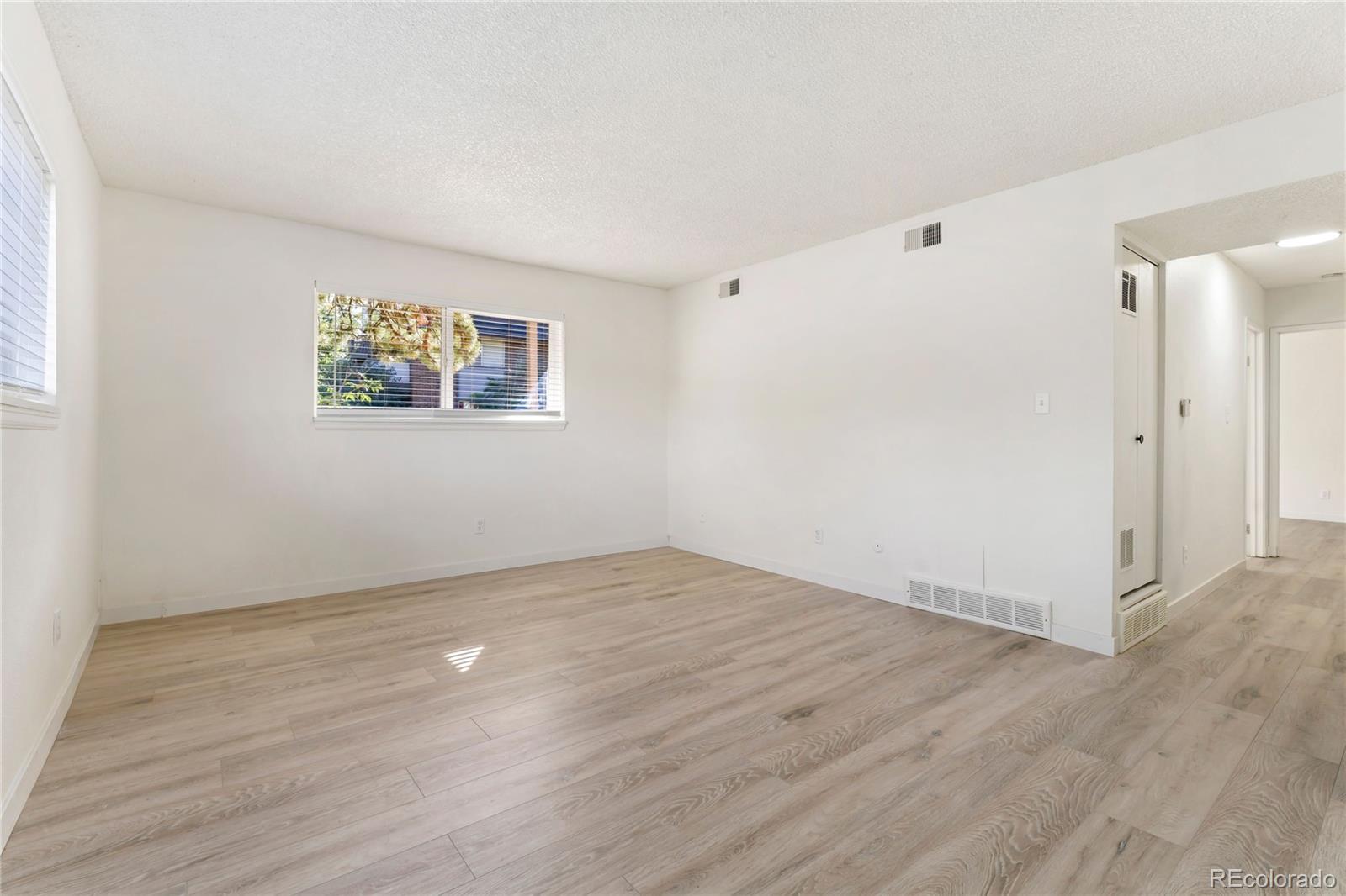 209 East Highline Circle, Unit 108 Centennial, CO 80122 - Photo 8 of 22 an empty room with wooden floor and window