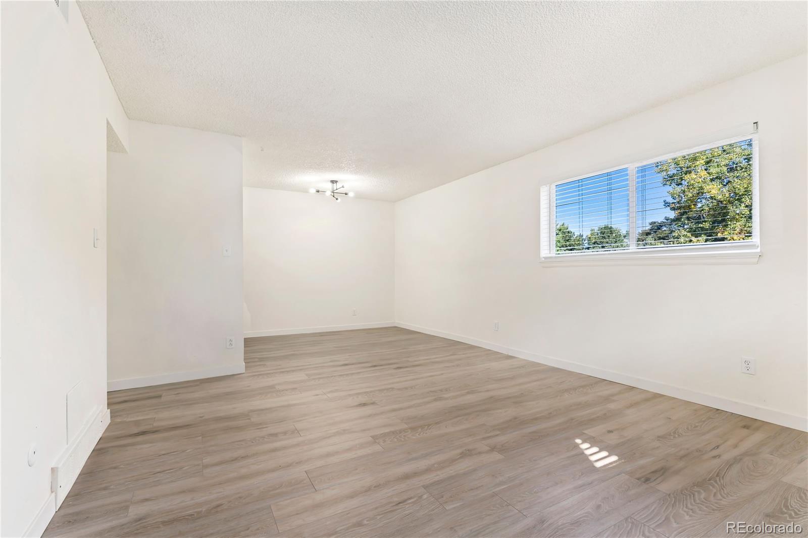 209 East Highline Circle, Unit 108 Centennial, CO 80122 - Photo 9 of 22 a view of an empty room with wooden floor and window