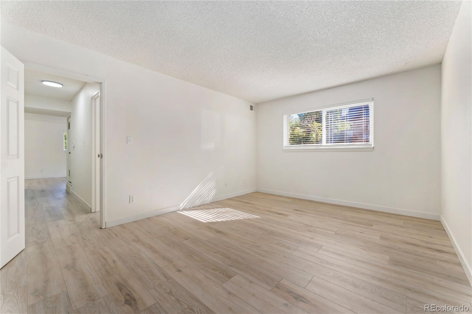 209 East Highline Circle, Unit 108 Centennial, CO 80122 - Photo 10 of 22 an empty room with wooden floor and windows