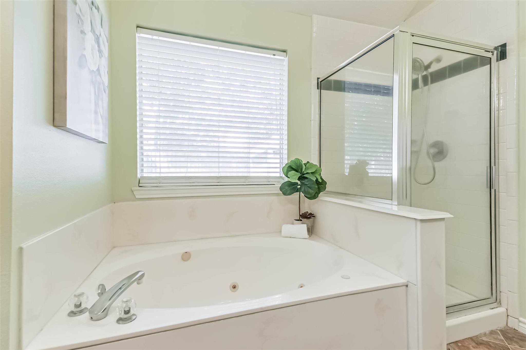 15027 Winding Black Cherry Lane Cypress, TX 77433 - Photo 16 of 37 a white bath tub sitting next to a white sink and a mirror