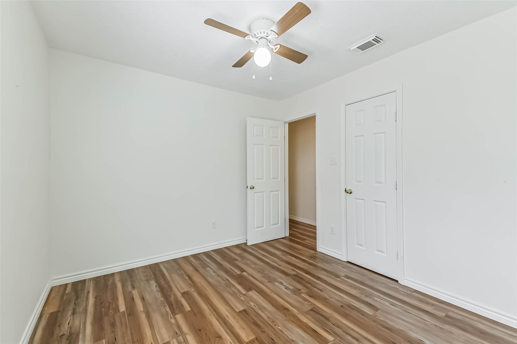 15027 Winding Black Cherry Lane Cypress, TX 77433 - Photo 19 of 37 a view of a room with wooden floor and a ceiling fan