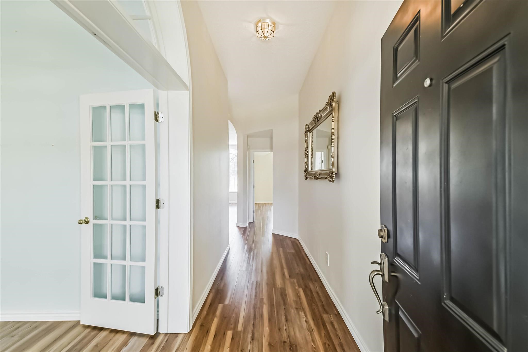 15027 Winding Black Cherry Lane Cypress, TX 77433 - Photo 2 of 37 a view of a hallway with wooden floor and staircase