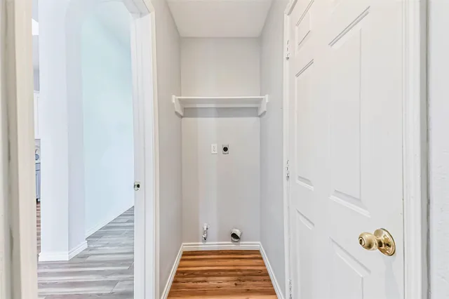 a view of empty room with wooden floor and fireplace