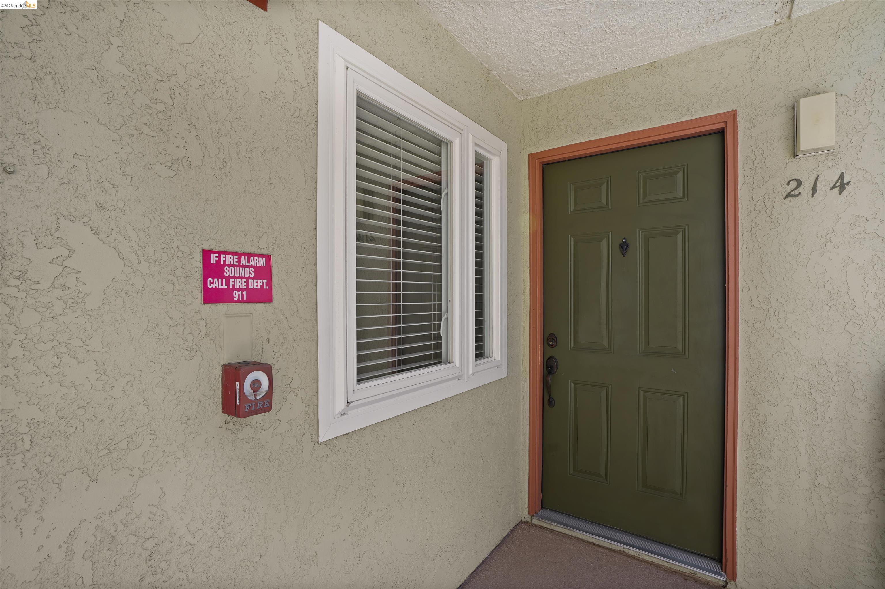 1505 Kirker Pass Road, Unit 214 Concord, CA 94521 - Photo 8 of 55 Entryway featuring a paneled door with contrasting trim, adjacent window with blinds, and stucco exterior