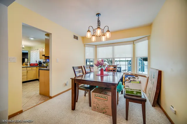 a view of a dining room with furniture and a chandelier