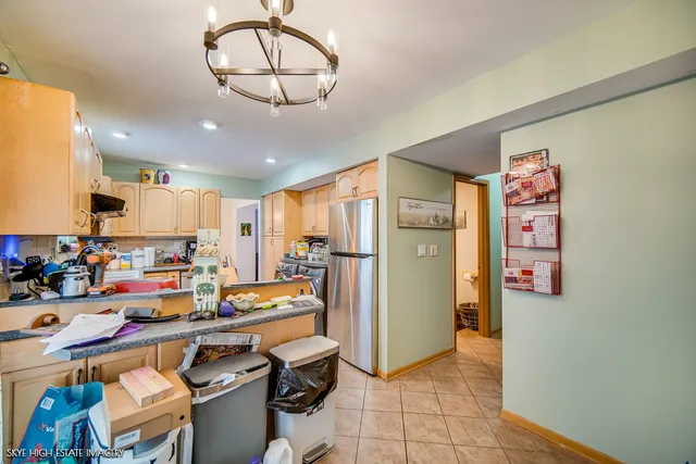 a very nice looking open kitchen with stainless steel appliances a refrigerator and a stove top oven