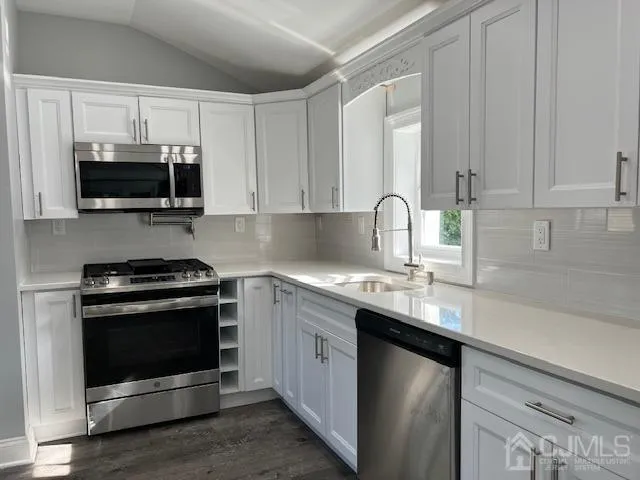 a kitchen with stainless steel appliances granite countertop a sink stove and microwave