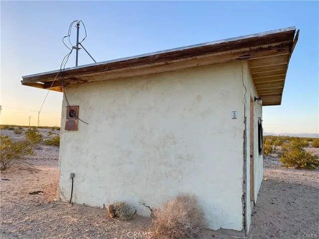 a view of a dry yard with wooden fence