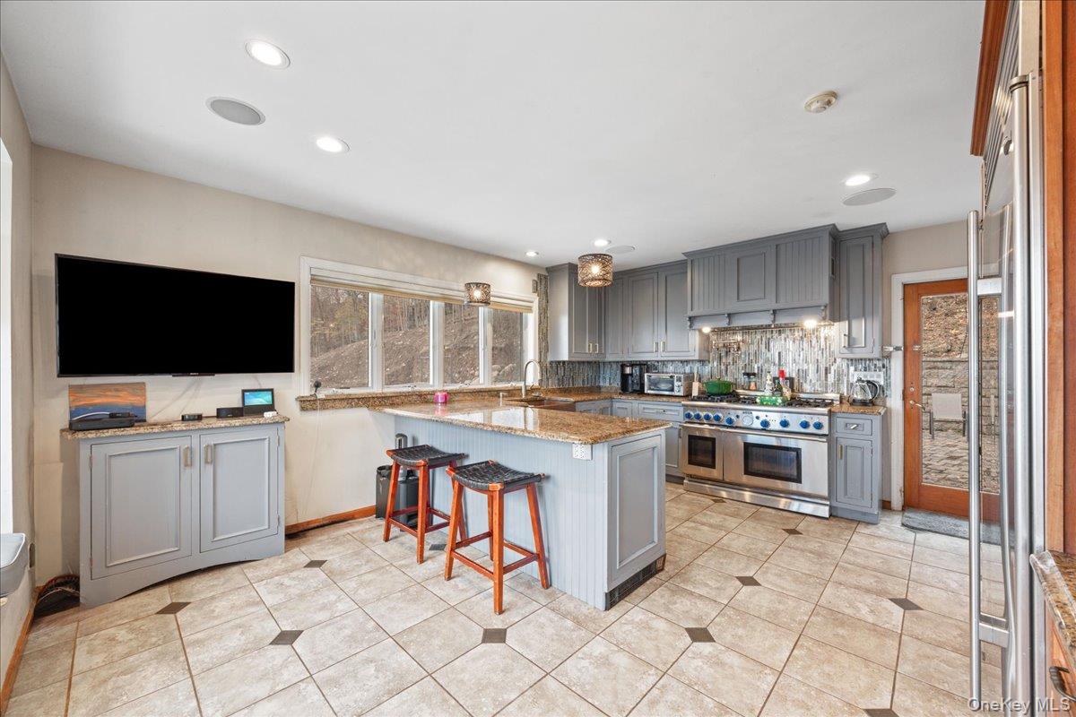 772 Rte 9W Nyack, NY 10960 - Photo 6 of 18 Kitchen with gray cabinets, a kitchen bar, high end appliances, recessed lighting, and light stone counters