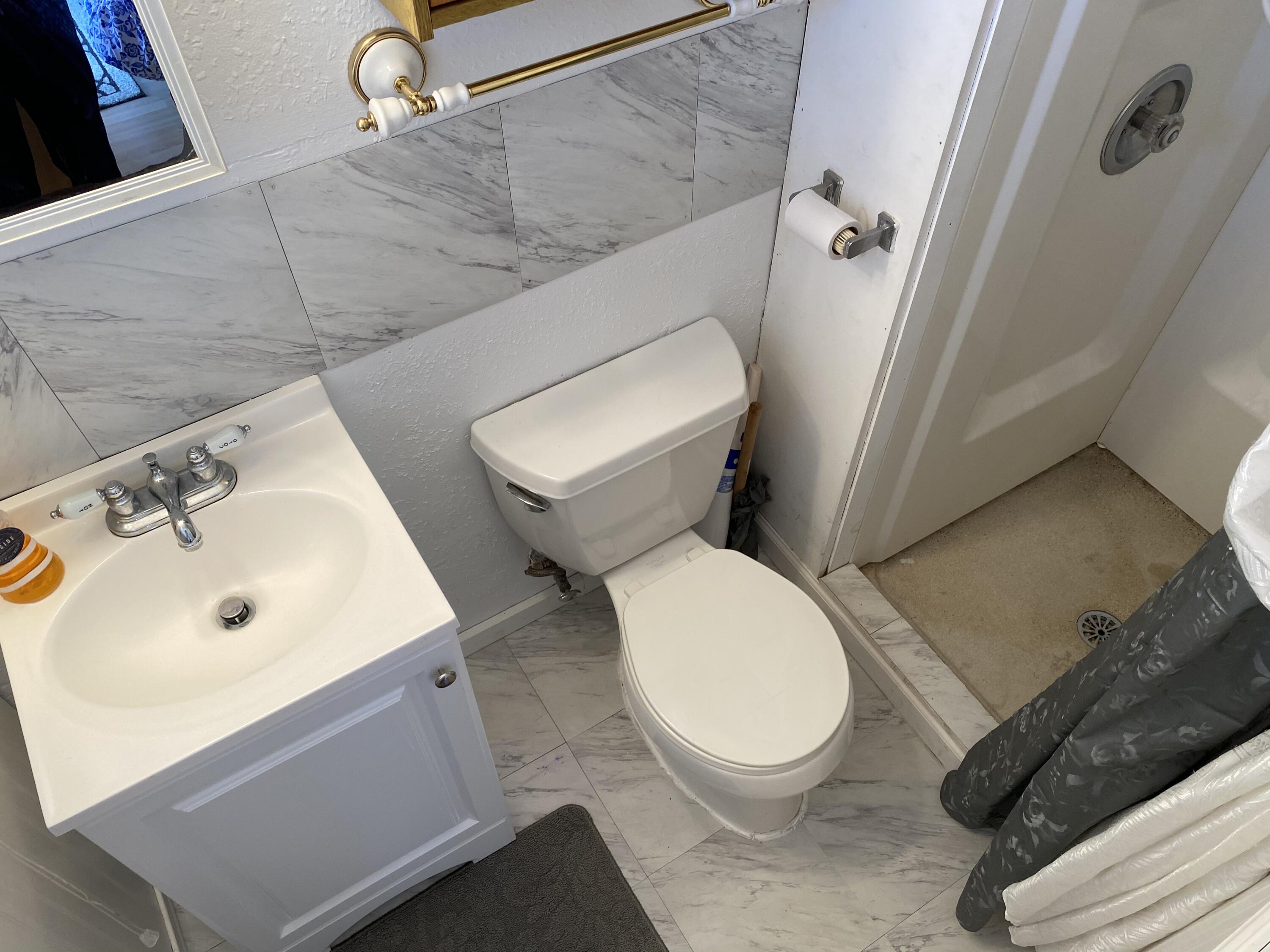 465 Lower County Road, Unit 3A Dennis Port, MA 02639 - Photo 20 of 33 a white toilet sitting next to a bathroom sink