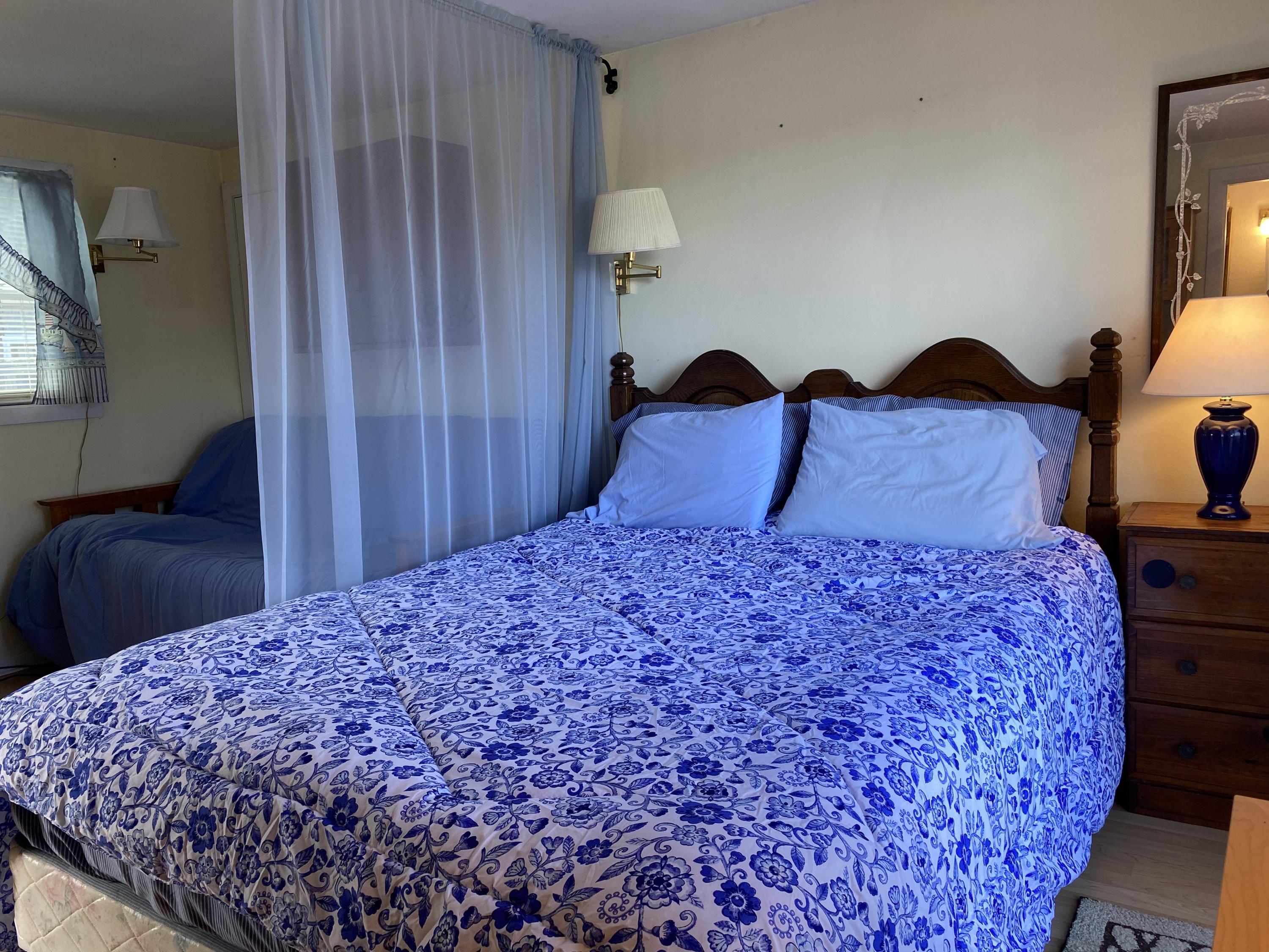 465 Lower County Road, Unit 3A Dennis Port, MA 02639 - Photo 9 of 33 a bedroom with a bed and a lamp on dresser