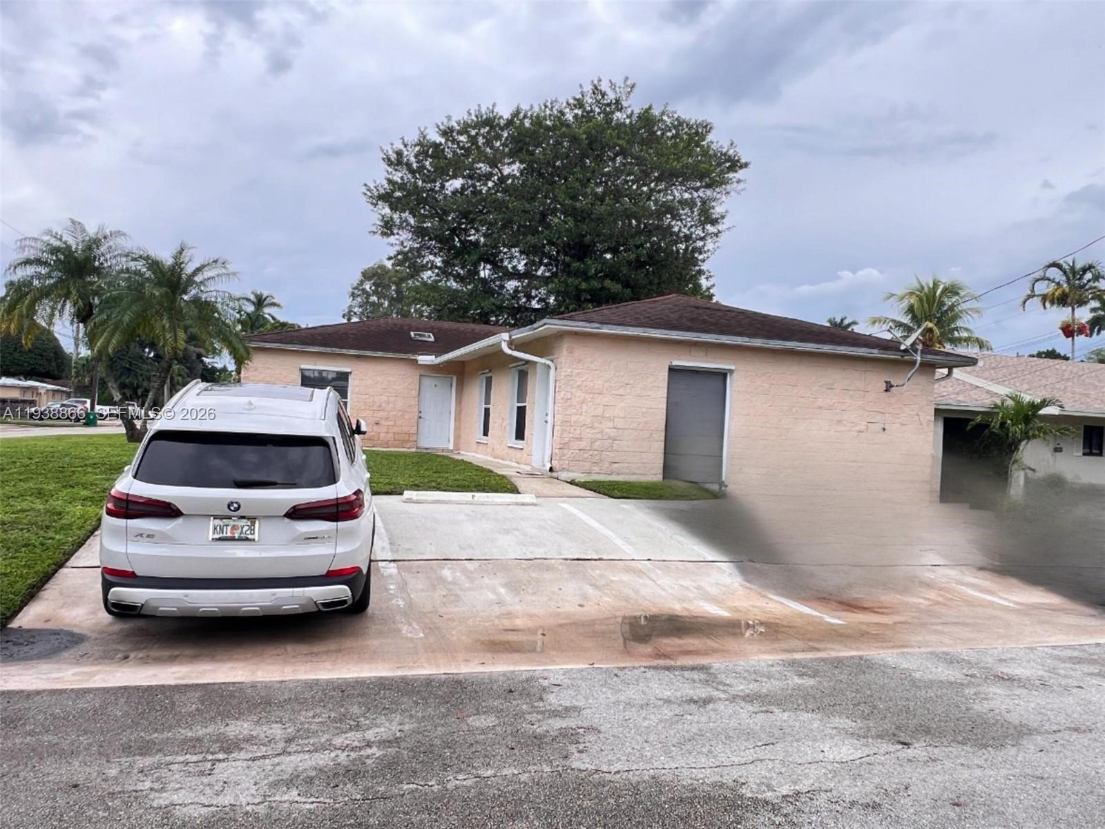 4865-4867 Southwest 65th Way, Unit AC Davie, FL 33314 - Photo 2 of 2 a car parked in front of white house