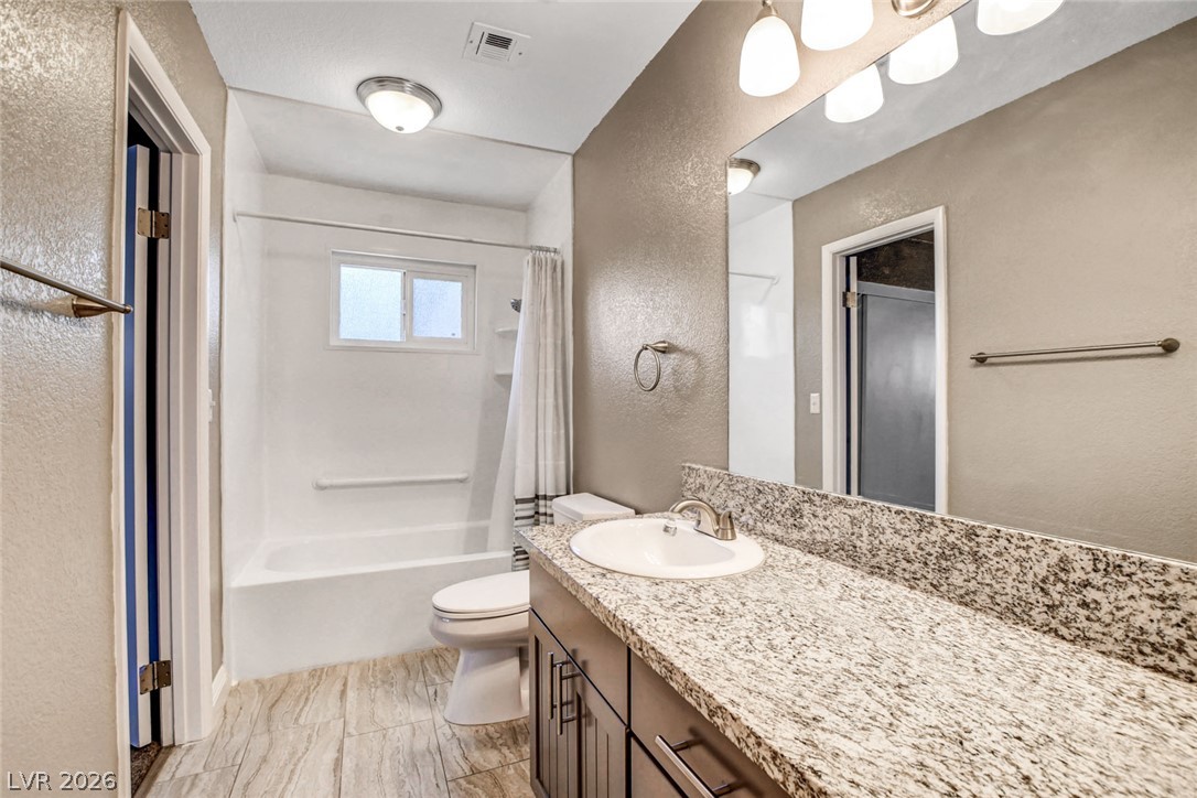 4367 South Mojave Road Las Vegas, NV 89121 - Photo 39 of 53 A well-appointed bathroom features a single vanity with stone counters and a tub/shower combination.