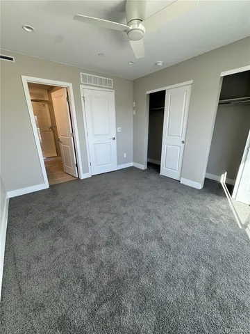 an empty room with staircase and a ceiling fan