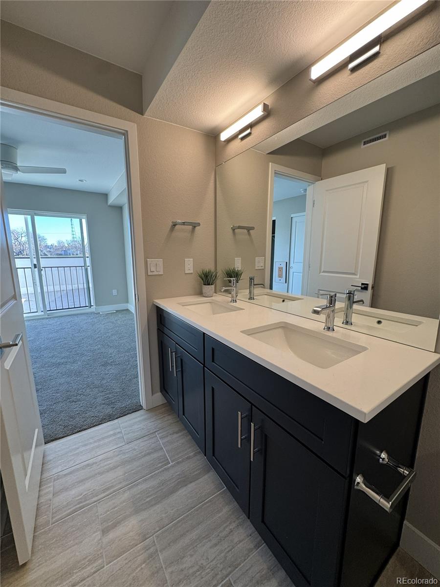 2660 South Delaware Street, Unit 9 Denver, CO 80223 - Photo 9 of 19 a bathroom with a double vanity sink and a mirror