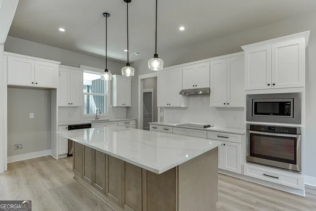 a view of an empty room with chandelier and window