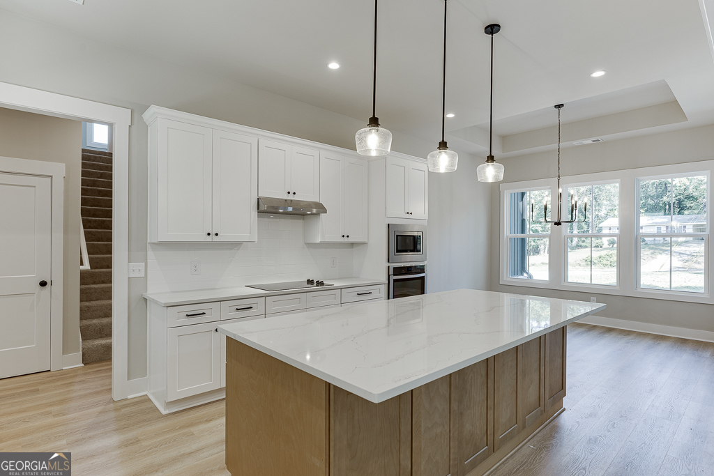 115 Rains Road Jefferson, GA 30549 - Photo 12 of 44 a kitchen with a stove a sink a window and chairs