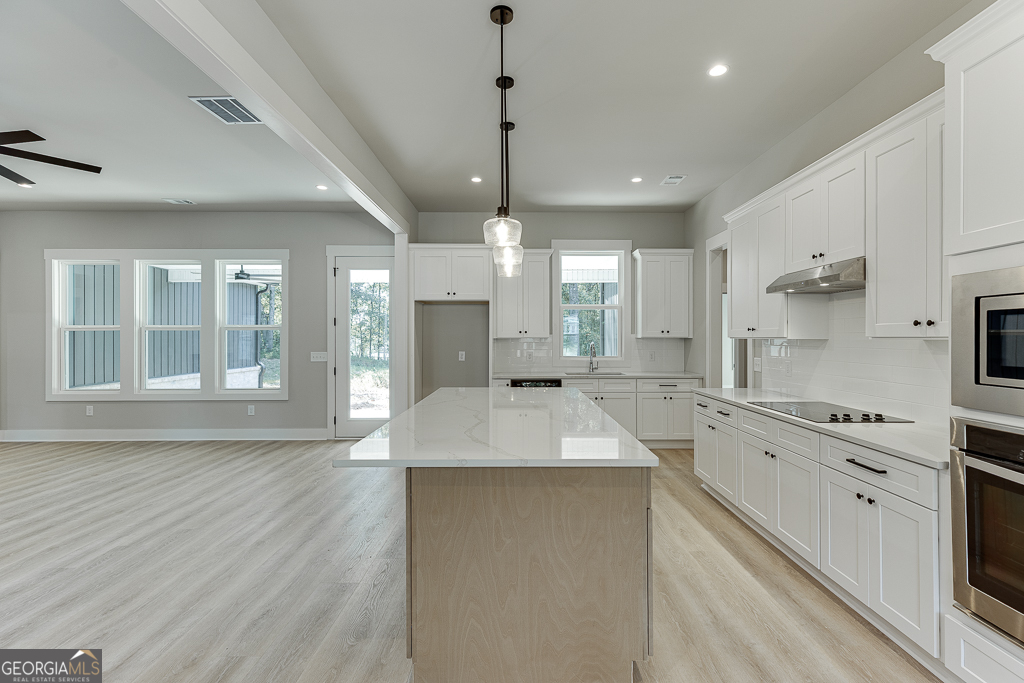 115 Rains Road Jefferson, GA 30549 - Photo 15 of 44 a large kitchen with granite countertop a large counter top appliances and cabinets