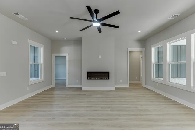 a large kitchen with kitchen island a island wooden floor stainless steel appliances and a window