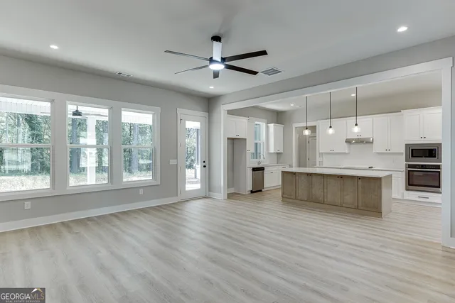 a large kitchen with kitchen island a stove a sink a center island and wooden floor