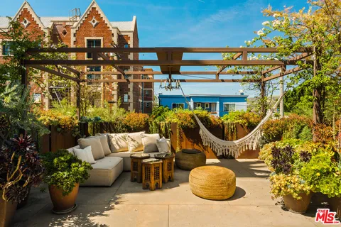 a view of a patio with couches table and chairs and potted plants