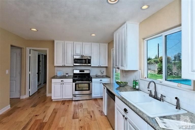 1391 Lowery Street Simi Valley, CA 93065 - Photo 8 of 16 a kitchen with stainless steel appliances granite countertop a sink stove microwave and refrigerator