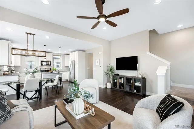a living room with furniture a flat screen tv and kitchen view