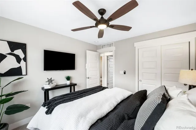 a bedroom with a bed a flat screen tv and a chandelier
