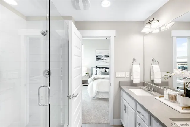 a bathroom with a double vanity sink mirror and shower