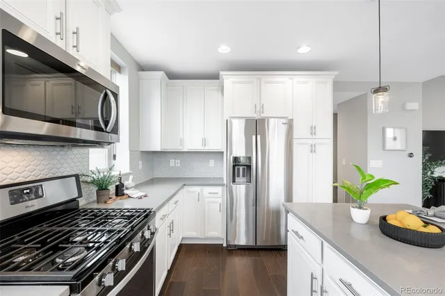 a kitchen with stainless steel appliances a stove a microwave a refrigerator a sink and wooden cabinets