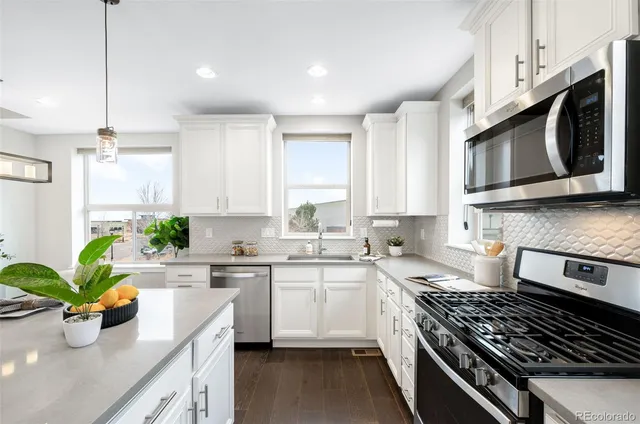 a kitchen with stainless steel appliances a stove sink microwave and cabinets
