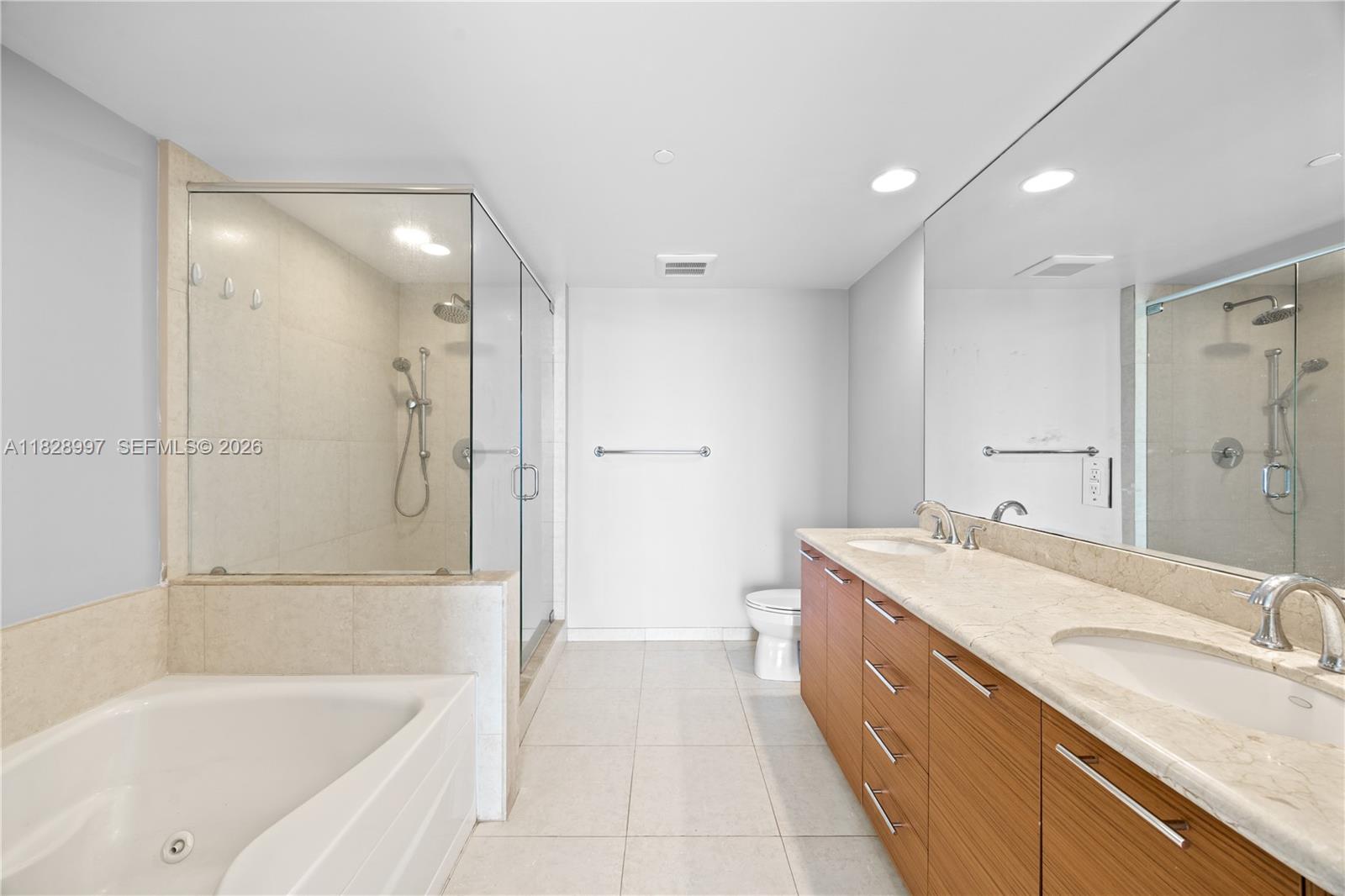 50 Biscayne Boulevard, Unit 4706 Miami, FL 33132 - Photo 16 of 49 a bathroom with a granite countertop tub sink shower and mirror
