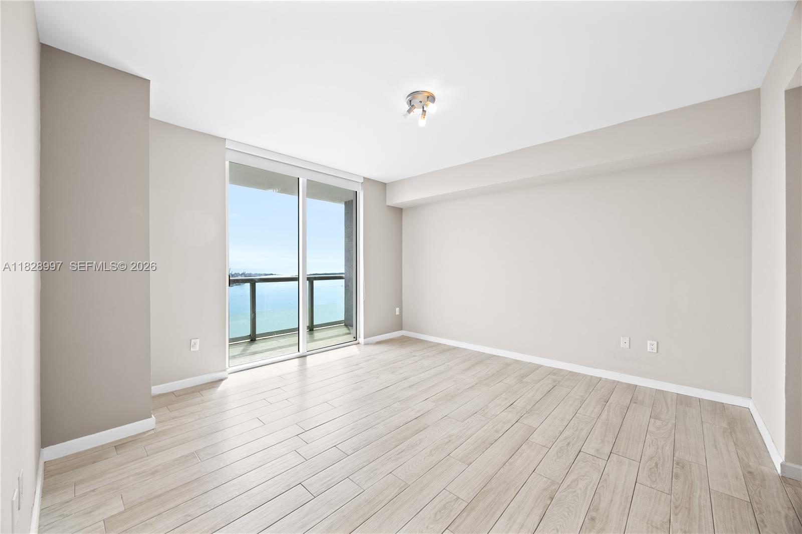 50 Biscayne Boulevard, Unit 4706 Miami, FL 33132 - Photo 17 of 49 wooden floor in an empty room with a window