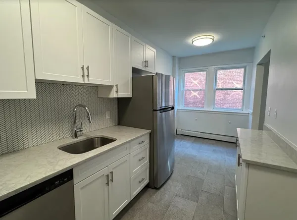 a kitchen with refrigerator and cabinets