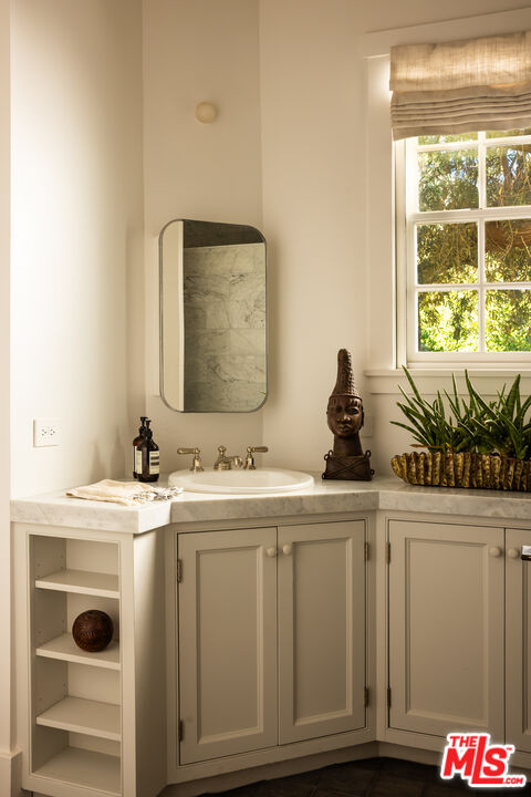 664 Elkins Road Los Angeles, CA 90049 - Photo 16 of 40 a bathroom with a sink and a mirror