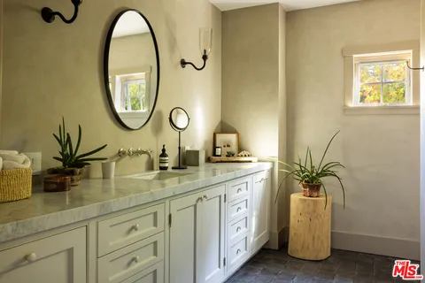 a bathroom with a granite countertop sink a mirror and a shower
