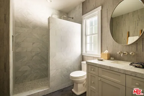 a bathroom with a granite countertop sink toilet and shower
