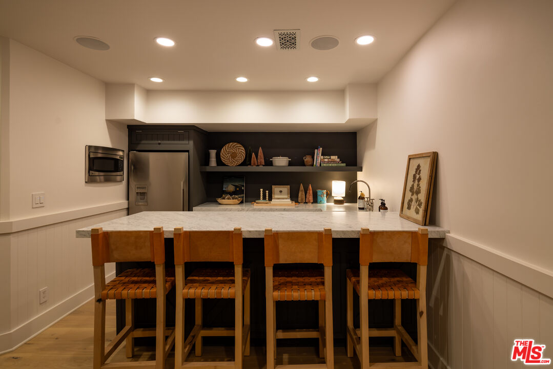 664 Elkins Road Los Angeles, CA 90049 - Photo 28 of 40 a kitchen with a dining table chairs and refrigerator