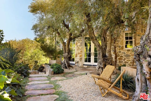 a view of a patio with couches table and chairs and potted plants